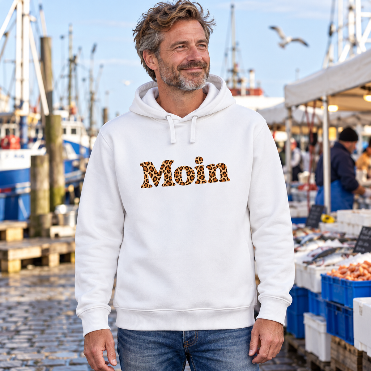 Weißer Bio Side Pocket Hoodie mit Moin-Leoprint auf einem Küstenfischmarkt