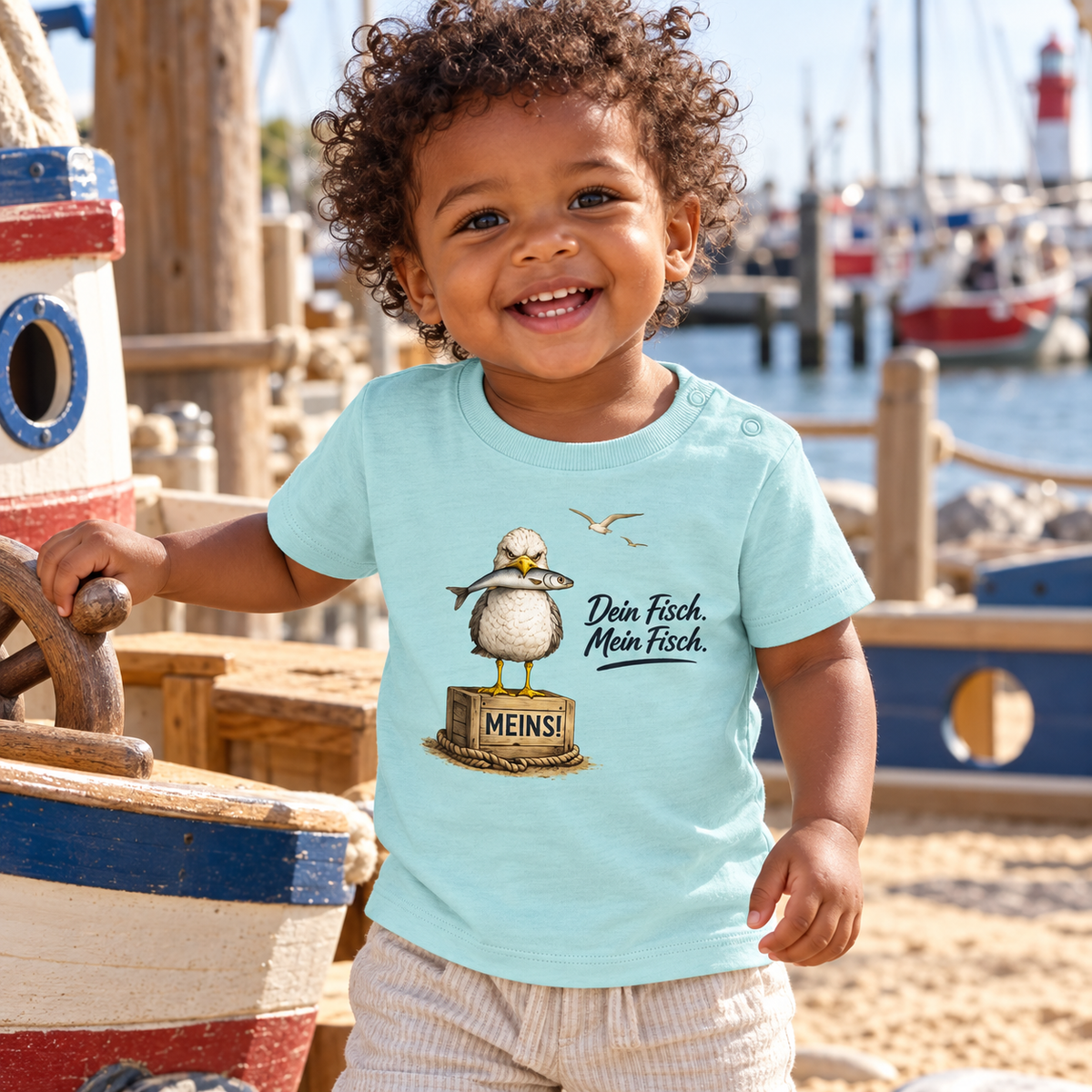 Kleinkind im Baby Bio T-Shirt Caribbean Blue mit „Dein Fisch. Mein Fisch.“ als Frontprint am Hafenspielplatz