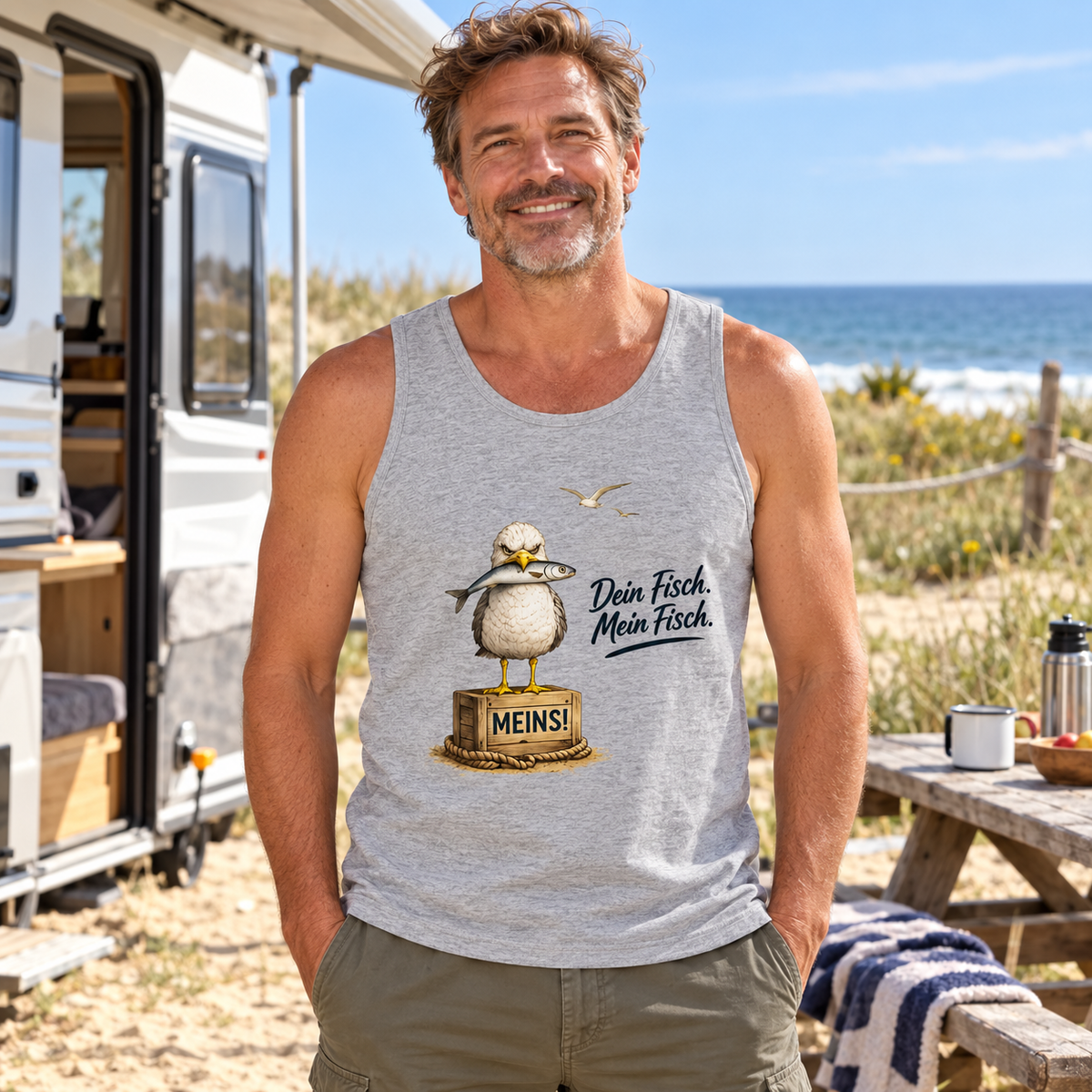Mann im Bio Tanktop Heather Grey mit Möwe, Fisch und Spruch als Frontprint am Küstencampingplatz