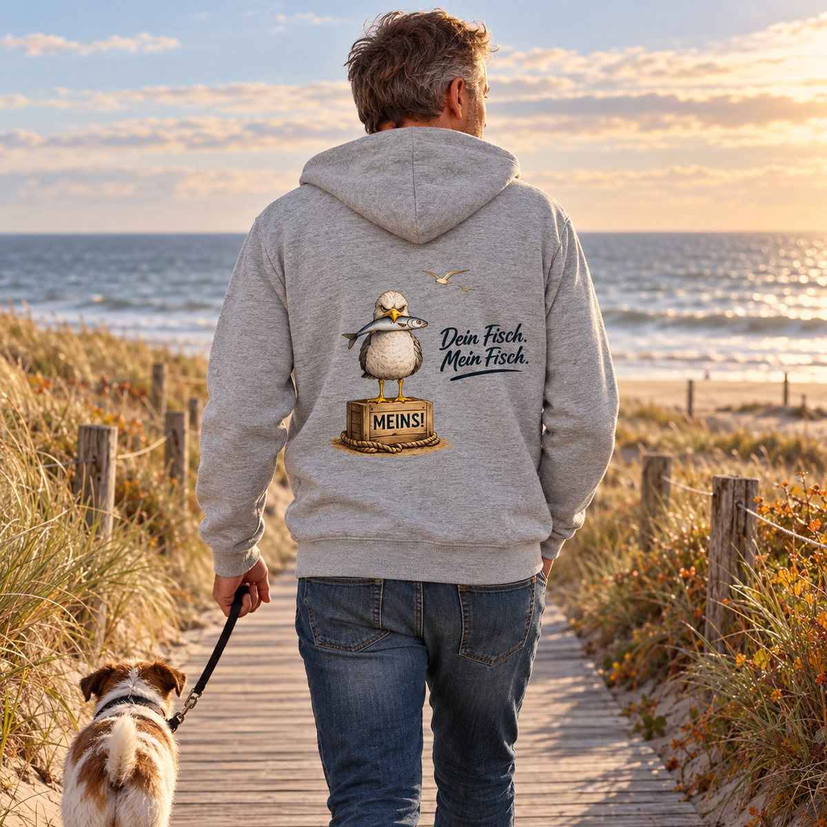 Bio Zipper Heather Grey mit „Dein Fisch. Mein Fisch.“ als Backprint auf einem Dünenweg mit Hund