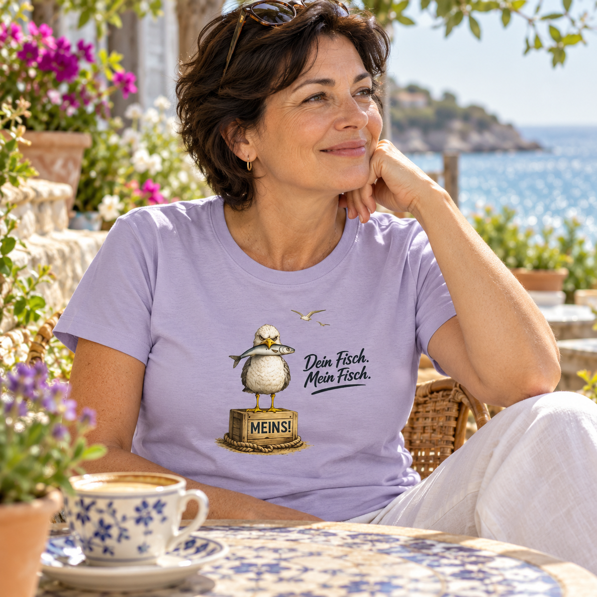 Frau im Damen Bio T-Shirt Lavender mit „Dein Fisch. Mein Fisch.“ als Frontprint im Küstencafé