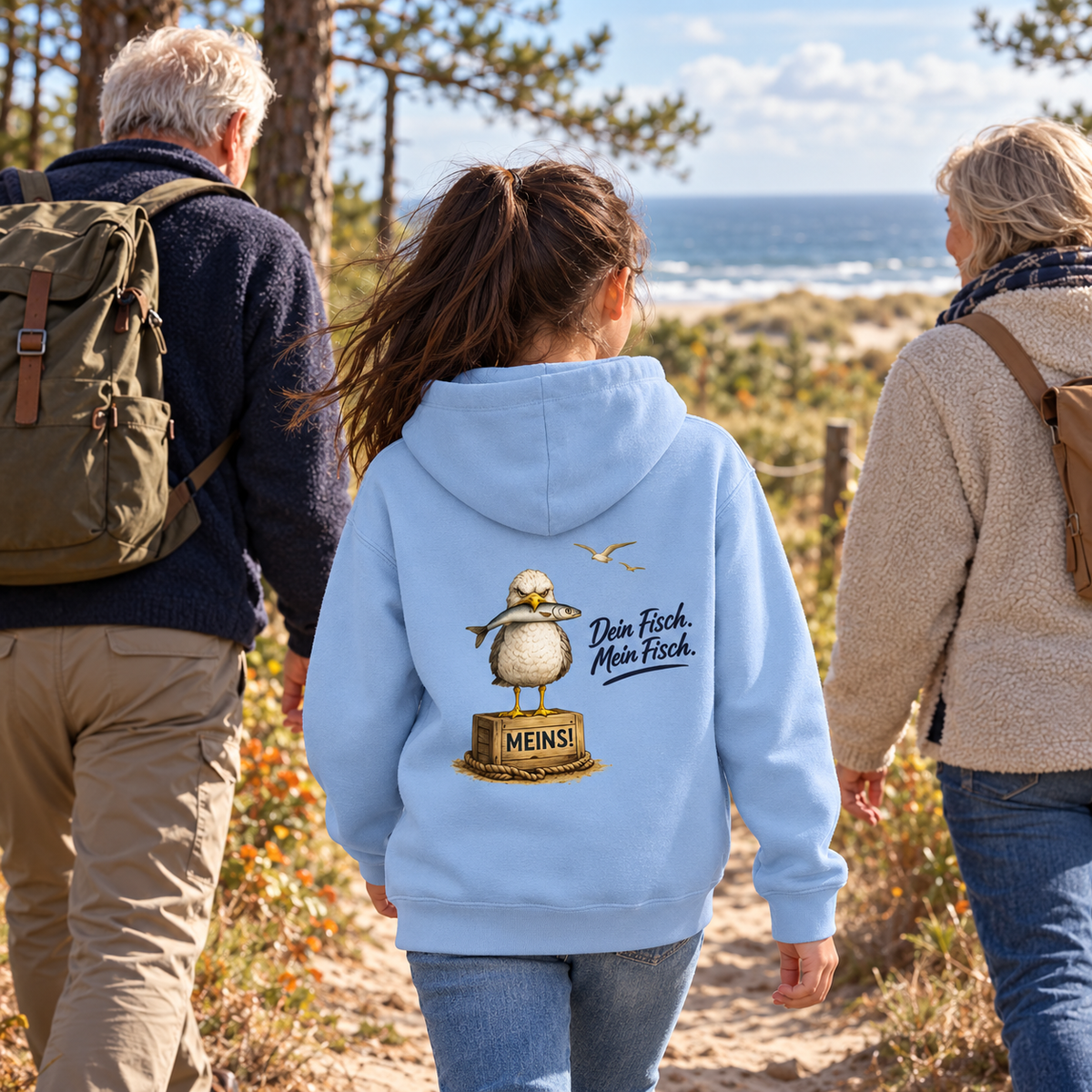 Kind im Kinder Bio Hoodie Blue Soul mit Möwen-Backprint auf einem Küstenweg mit Großeltern