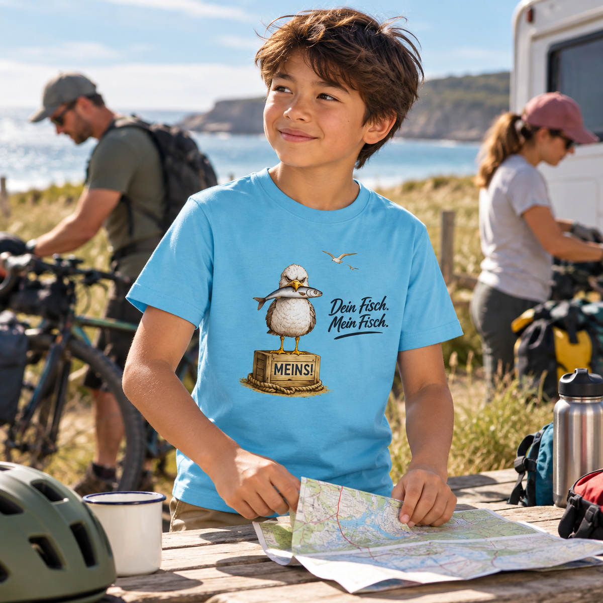 Kind im Kinder Bio T-Shirt Aqua Blue mit Möwen-Frontprint vor einer Radtour am Meer