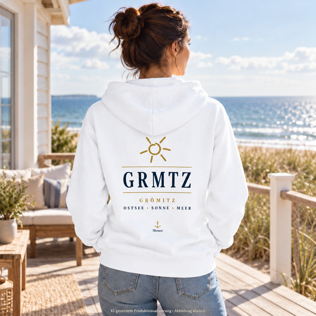Frau im weißen GRMTZ Grömitz Bio-Zipper auf einer Ferienhausveranda – maritimer Rückendruck; KI-Visualisierung.