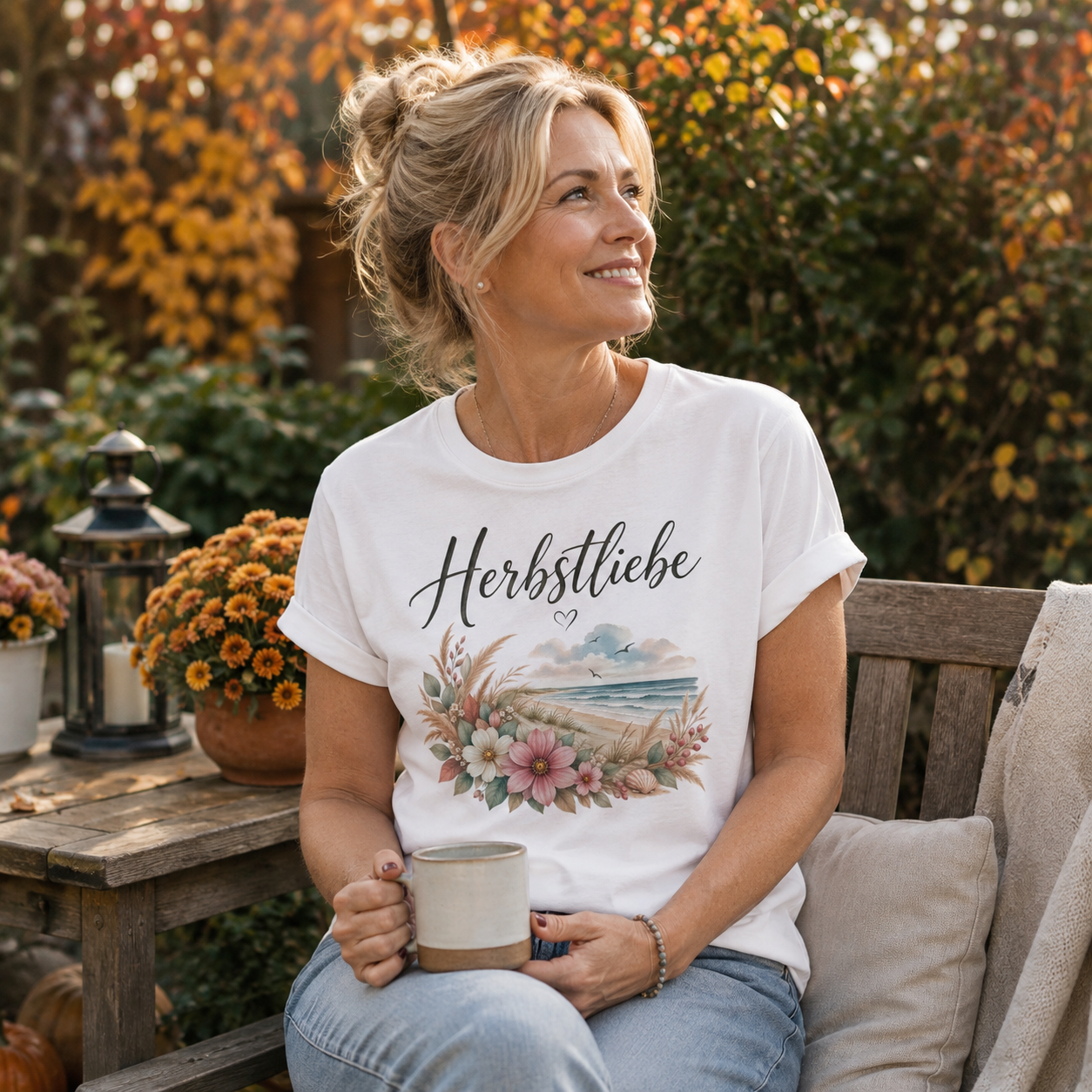 Frau mittleren Alters trägt weißes Nomavé Damen T-Shirt Herbstliebe am Meer mit Umschlagärmeln in herbstlichem Garten