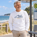 Kühlungsborn Baltic Waves Bio-Unisex-Sweatshirt Light Edition in White an einer Küstenbushaltestelle – KI-Produktvisualisierung