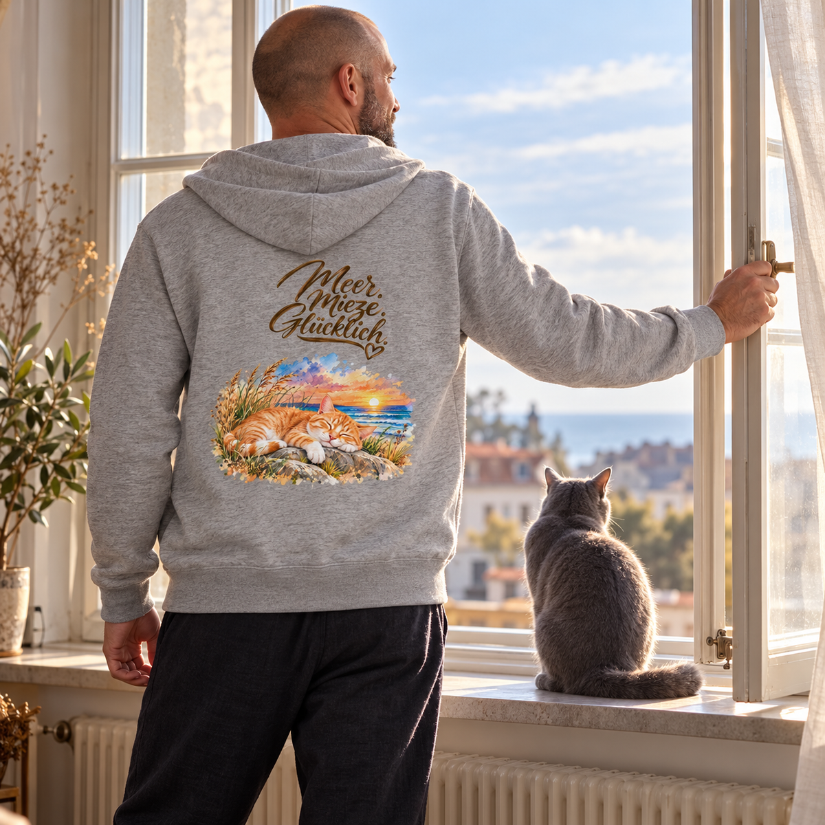 Mann in einer grauen Kapuzenjacke mit Katzen-Backprint öffnet ein Fenster neben einer grauen Katze.