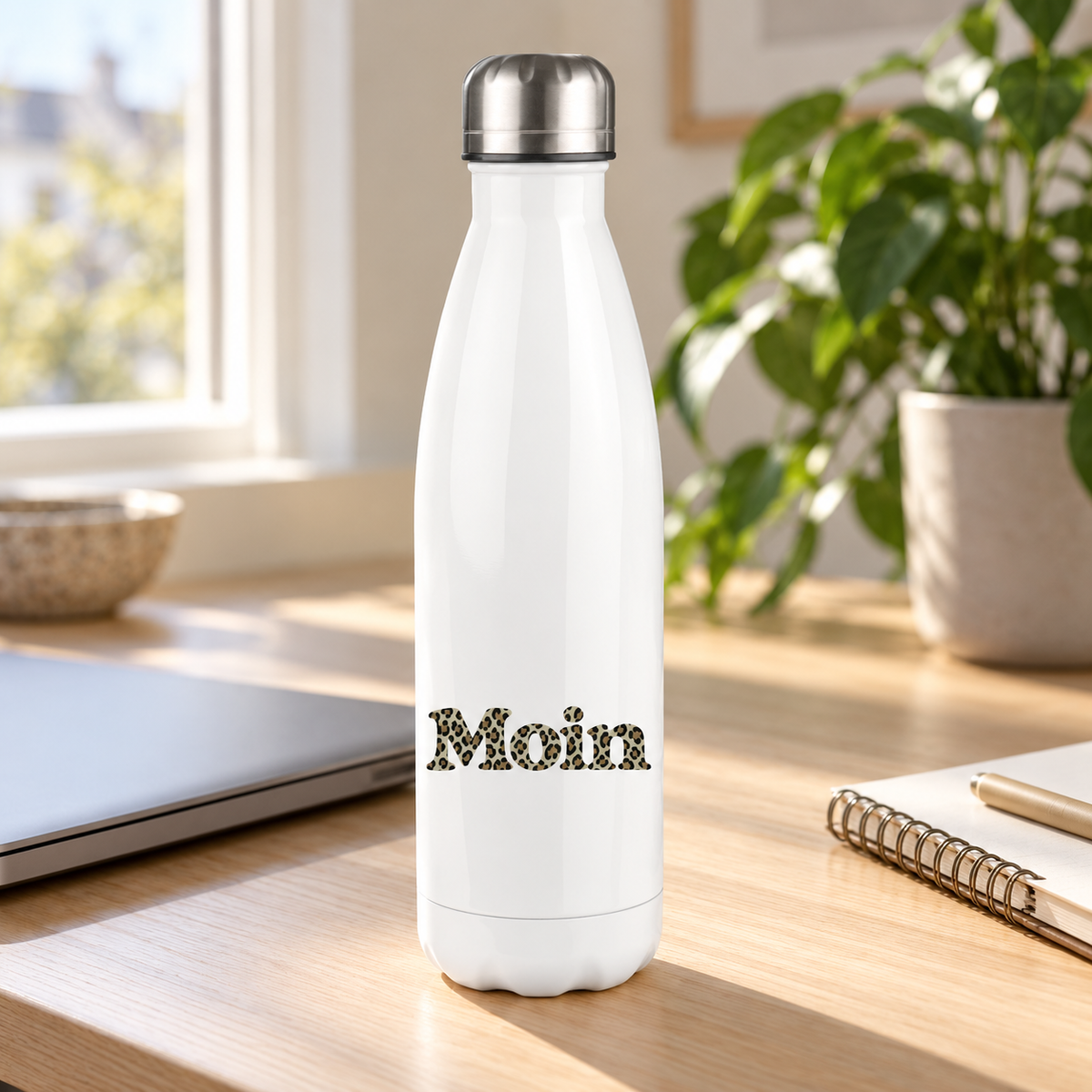 Weiße Edelstahl-Thermoflasche mit silbernem Deckel und Moin-Leoprint in Sage Green auf einem Schreibtisch am Fenster.
