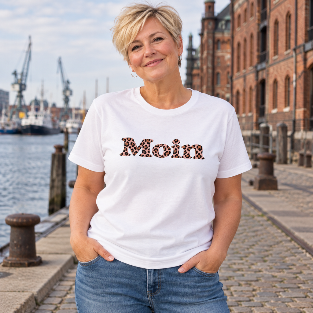 Frau am Hafen trägt ein weißes Bio-Unisex-T-Shirt mit Moin-Leo-Blush-Pink-Frontprint.