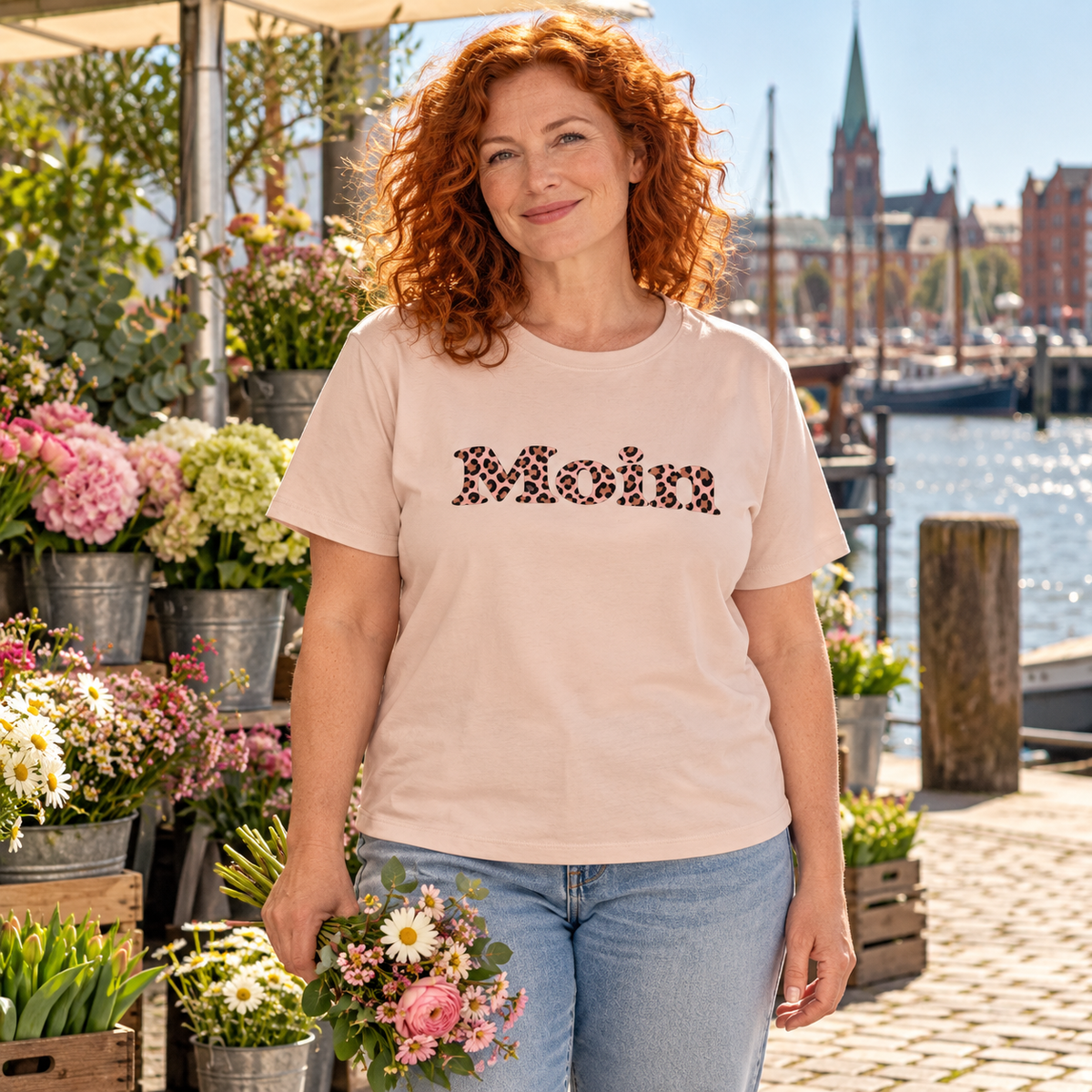 Frau am Blumenstand mit Damen-Bio-T-Shirt in Fraiche Peche und Moin-Leo-Blush-Pink-Frontprint.