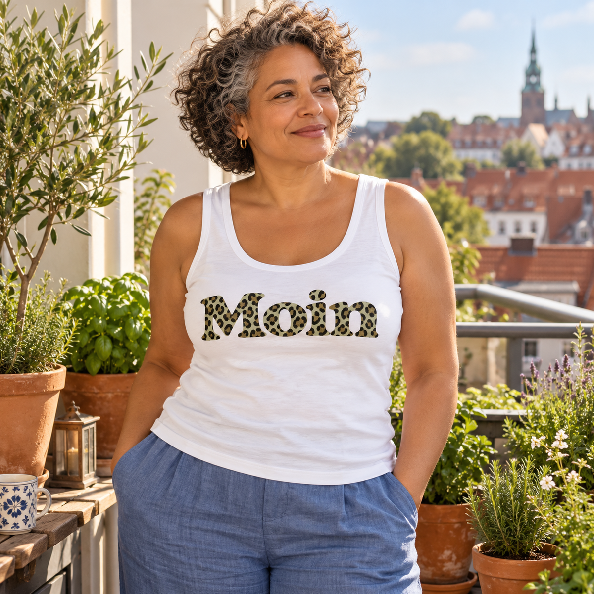Frau im weißen Damen Bio Fitted Tank Top mit Moin-Leoprint in Sage Green im Balkongarten, Vorderansicht.