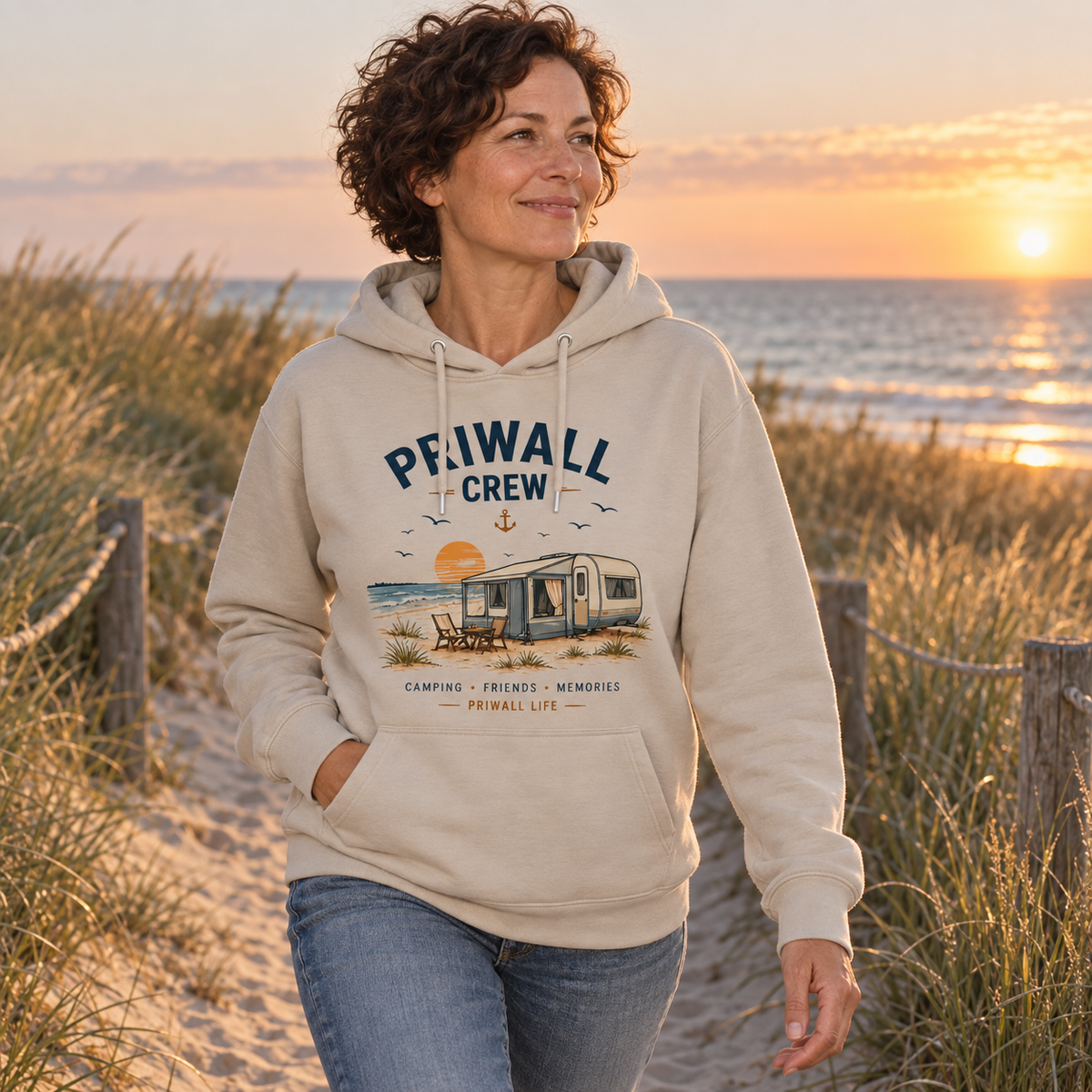 Frau im Desert-Dust Bio Hoodie mit Priwall-Crew-Motiv auf einem Dünenweg am frühen Ostseemorgen