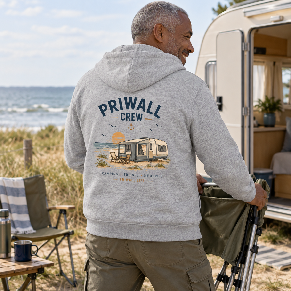 Mann im Heather-Grey Bio-Zipper mit Priwall-Crew-Backprint beim Camping an der Ostseeküste