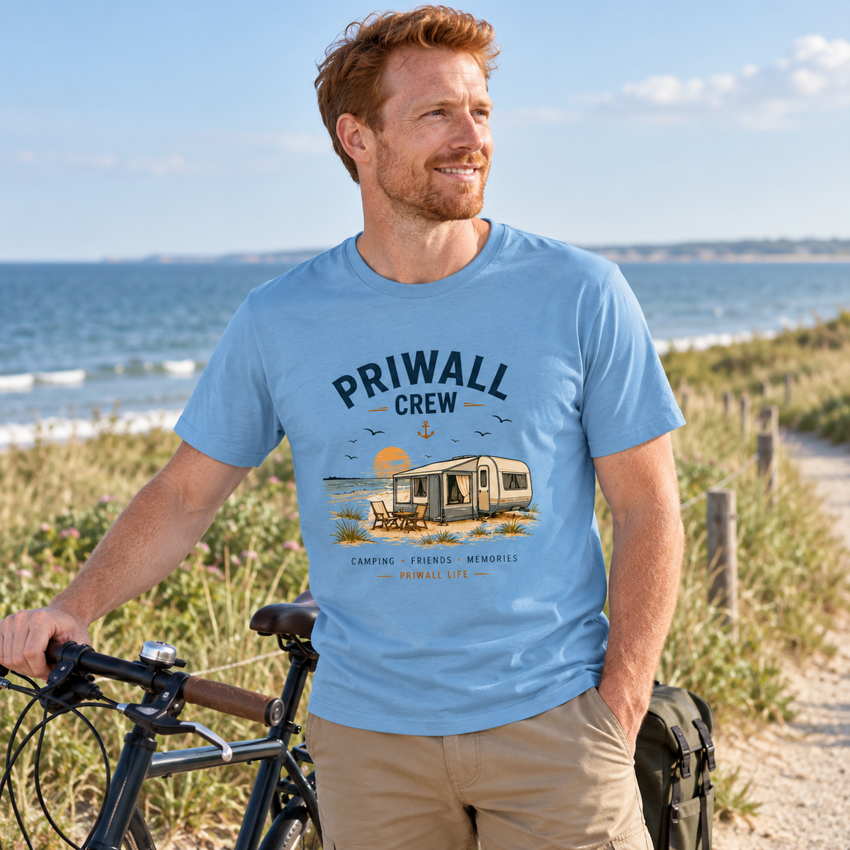 Mann im Carolina-Blue Priwall-Crew Essential T-Shirt bei einer Fahrradpause am Ostsee-Küstenweg