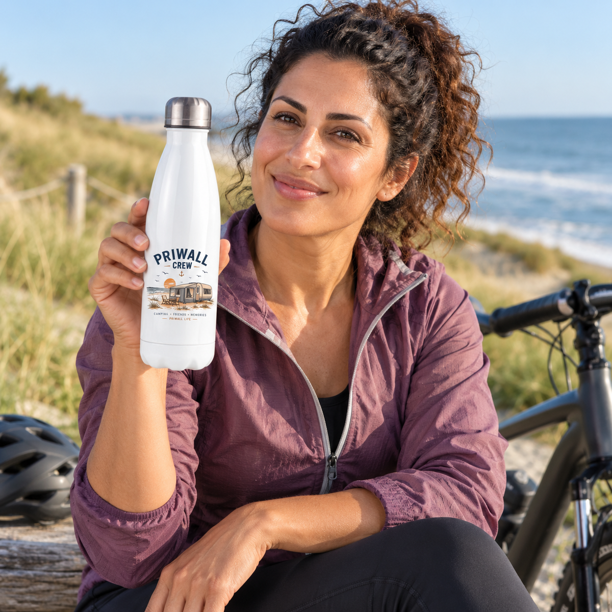 Frau mit weißer Priwall-Crew Thermoflasche bei einer Fahrradpause am Ostsee-Küstenweg