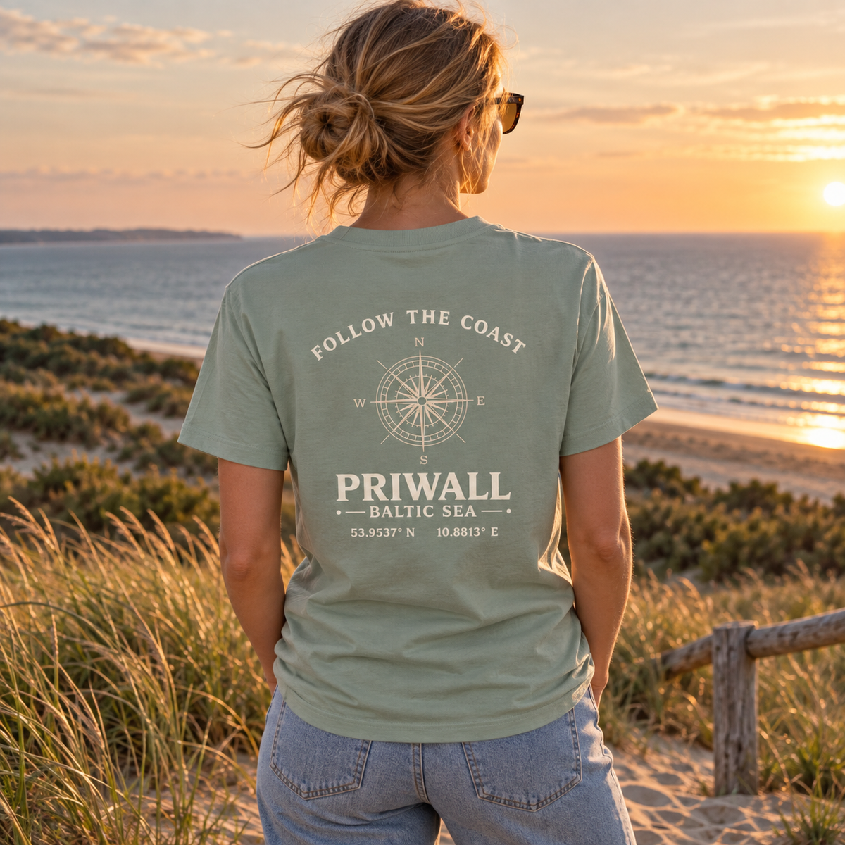 Frau im grünen Priwall Follow the Coast Bio Heavy T-Shirt mit Rückenmotiv an einem Ostsee-Aussichtspunkt