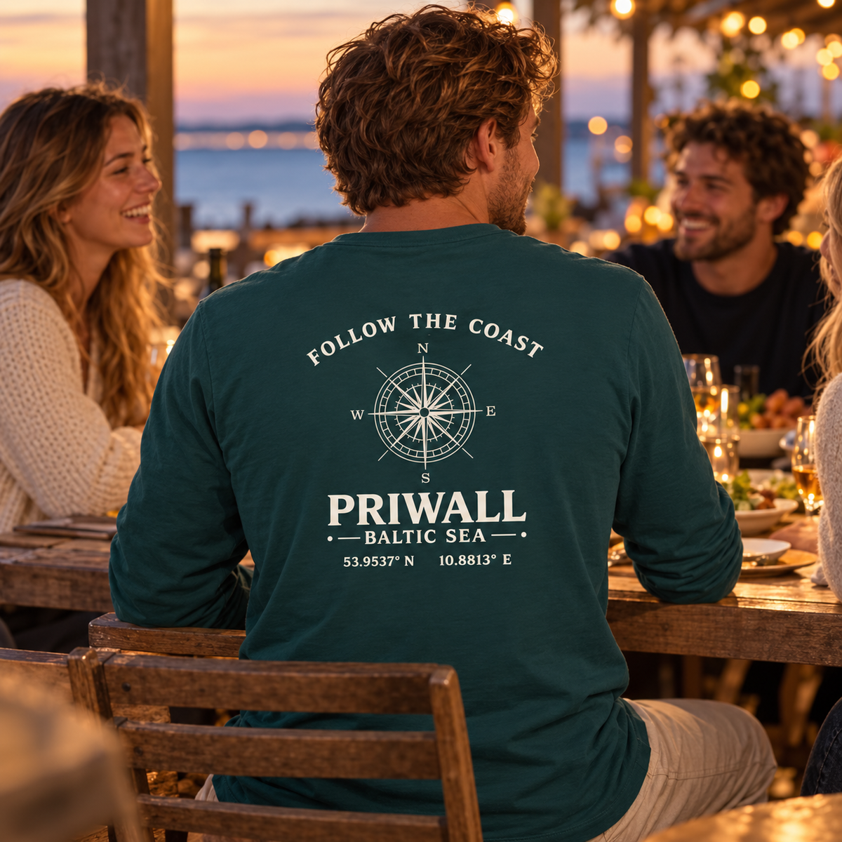 Mann im grünen Priwall Follow the Coast Bio Longsleeve mit Backprint beim Restaurantbesuch mit Freunden