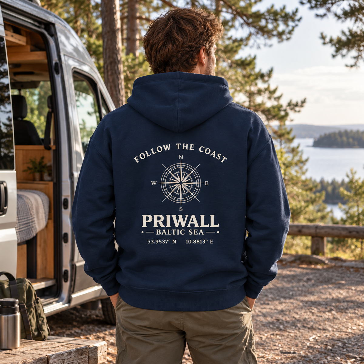 Mann im dunkelblauen Priwall Follow the Coast Bio Oversize Hoodie mit Rückenmotiv bei einer Roadtrip-Pause