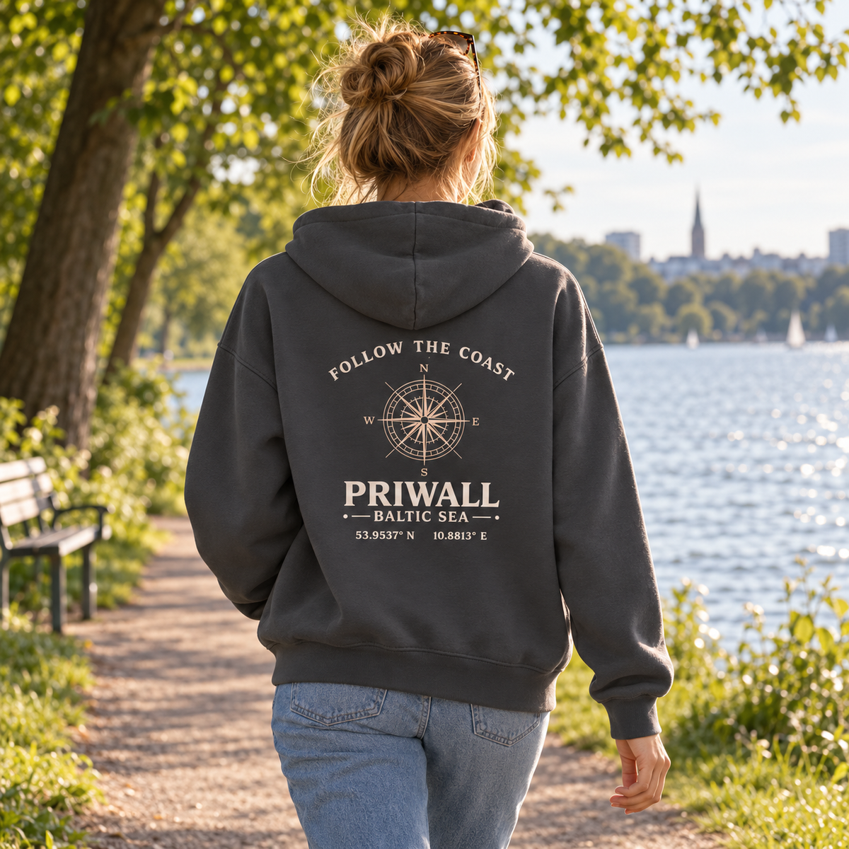 Frau im Priwall Follow the Coast Damen Bio Boxcut Hoodie mit Rückenmotiv beim Spaziergang am See