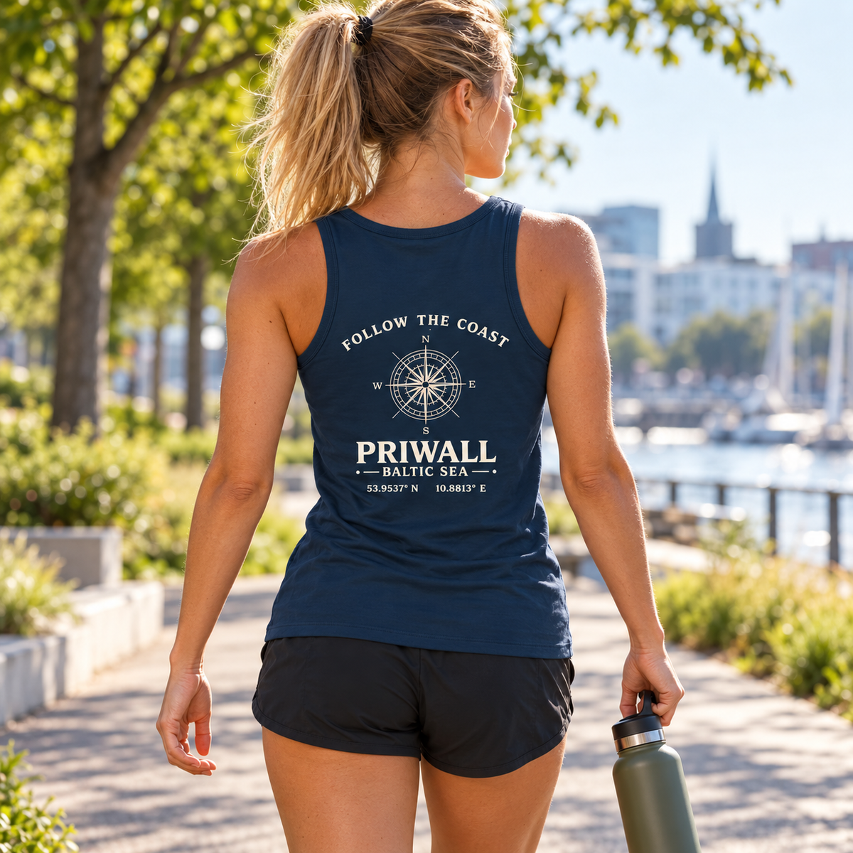 Frau im dunkelblauen Priwall Follow the Coast Damen Bio Fitted Tank Top mit Backprint nach dem Parklauf
