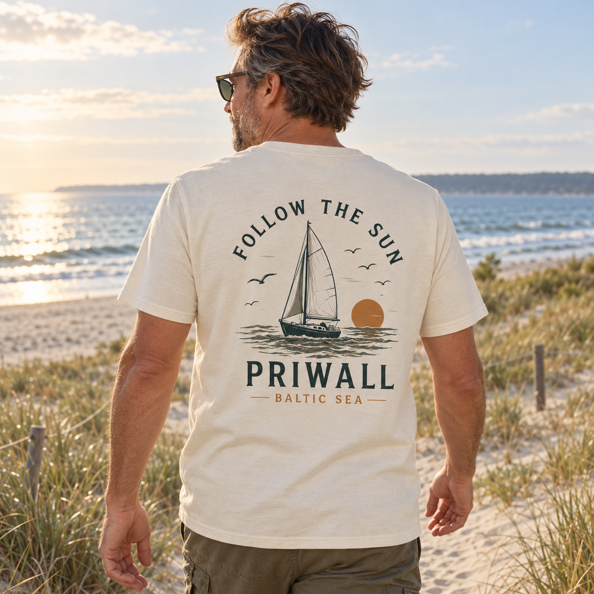 Mann im Natural Raw Priwall Follow the Sun Bio T-Shirt mit Rückenprint am Ostseestrand