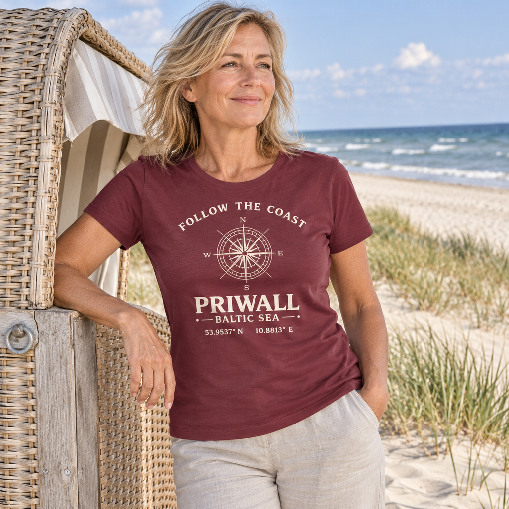 Frau trägt Priwall Kompass Dark Edition Ladies Organic Shirt in Burgundy am Ostseestrand