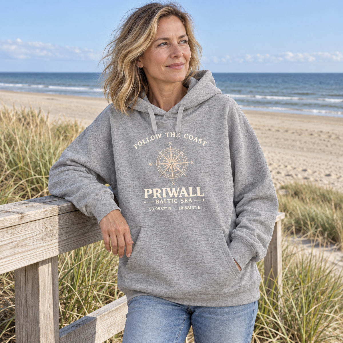 Frau trägt Priwall Kompass Dark Edition Organic Oversize Hoodie in Heather Grey an den Ostseedünen