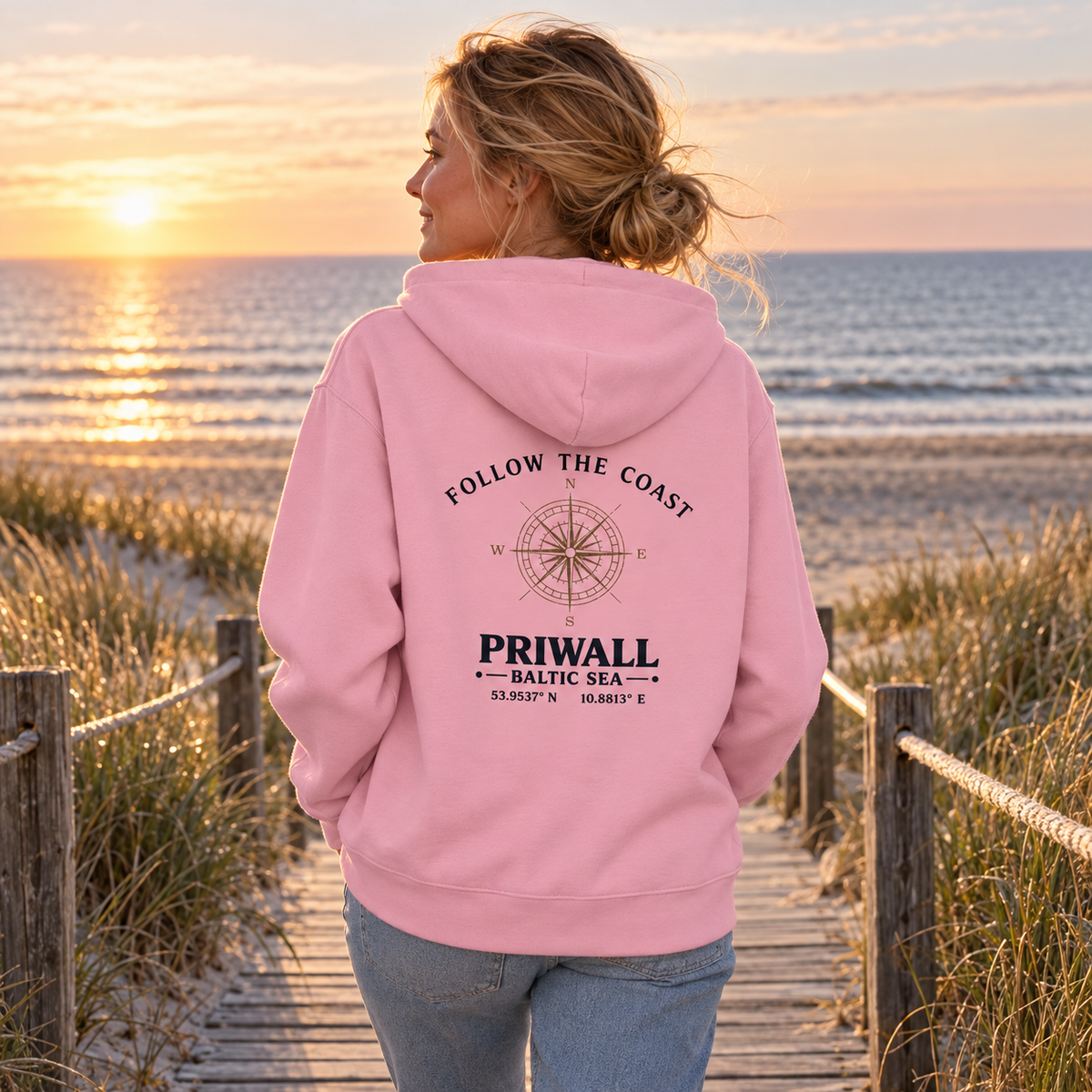 Frau im Bio Hoodie mit hellem Follow the Coast Rückenmotiv auf einem Ostsee-Dünenweg
