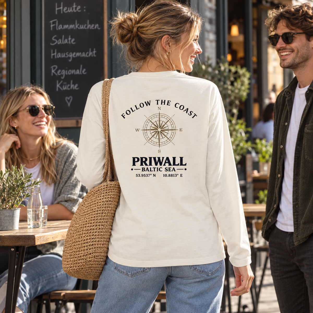 Frau im Bio Longsleeve mit hellem Follow the Coast Rückenmotiv beim Treffen mit Freunden