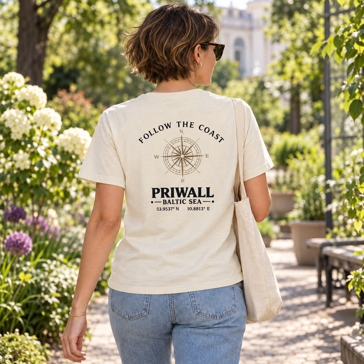 Frau im Bio T-Shirt mit hellem Priwall Backprint bei einem Spaziergang im botanischen Garten
