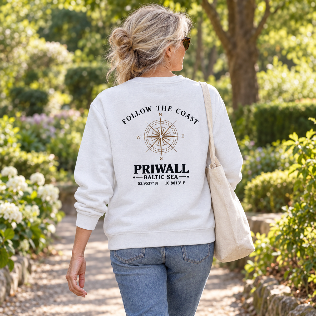 Frau im Bio Unisex Sweatshirt mit hellem Priwall Rückenmotiv im Park