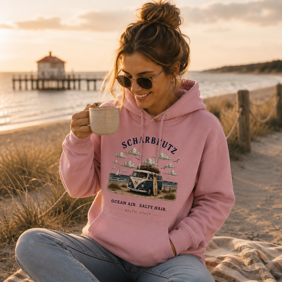 Frau im Cotton Pink Scharbeutz Bulli Bio-Hoodie am Ostseestrand