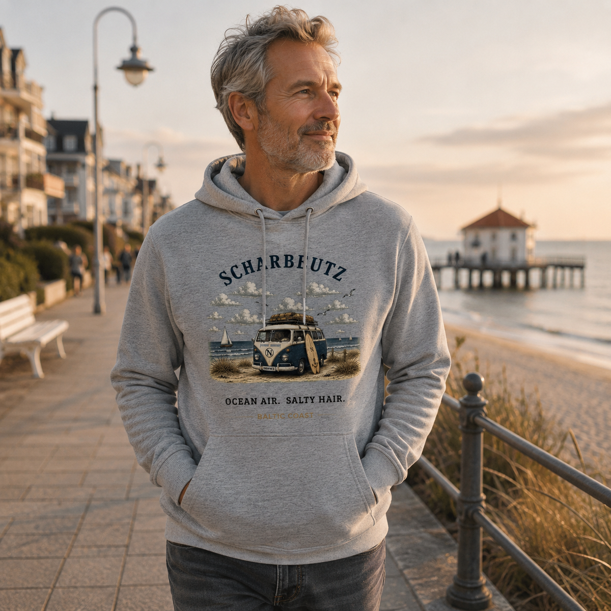 Mann im Heather Grey Scharbeutz Bulli Bio-Hoodie an der Promenade