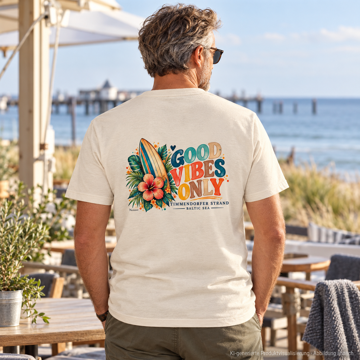 KI-generierte Produktvisualisierung: Unisex Bio-T-Shirt in Natural Raw mit Timmendorfer-Surf-Vibes-Rückenprint, Mann auf einer Küstencafé-Terrasse.