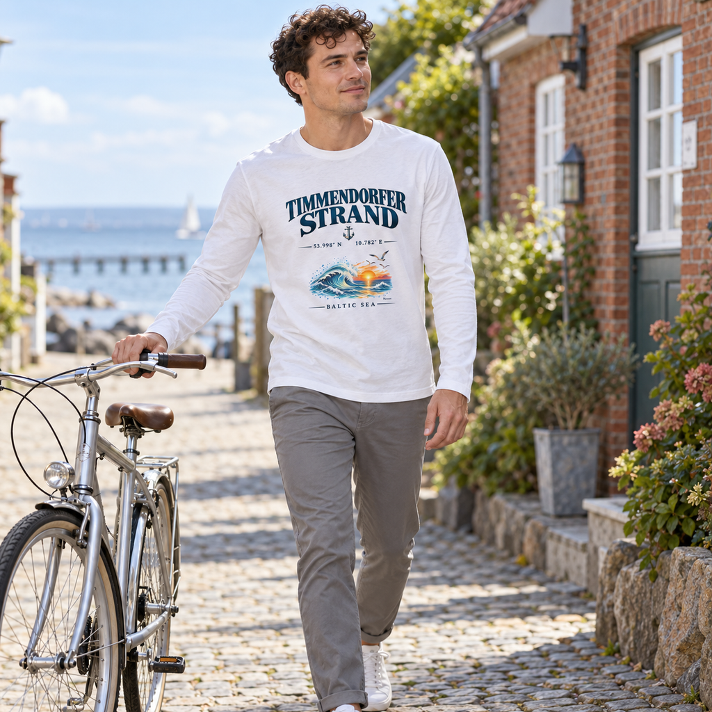 Mann im weißen Unisex Bio-Longsleeve mit Baltic Sea Frontprint beim Spaziergang mit einem Fahrrad durch eine Küstenstraße.