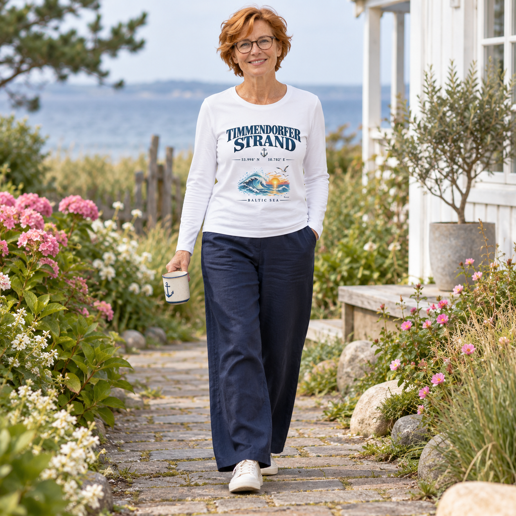 Damen Bio-Longsleeve in Weiß mit Timmendorfer-Strand–Baltic-Sea-Frontmotiv: Frau mit Brille trägt eine Tasse im Garten.