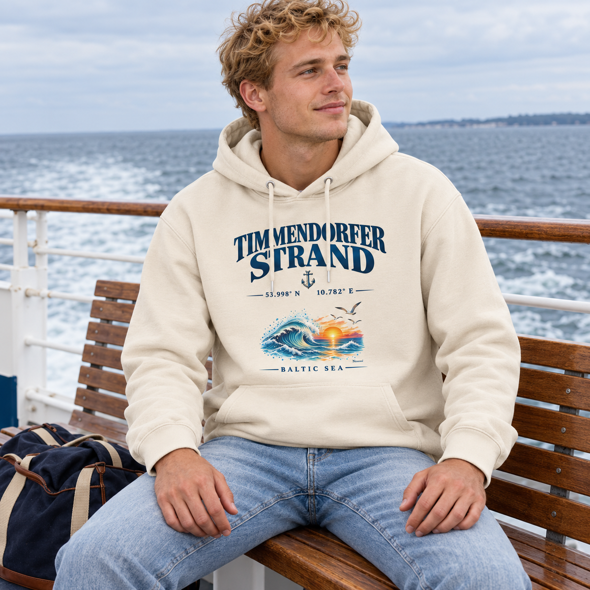 Unisex Bio-Hoodie in Natural Raw mit Timmendorfer-Strand–Baltic-Sea-Frontmotiv: Mann sitzt auf einer Bank an Deck mit Ostseeblick.