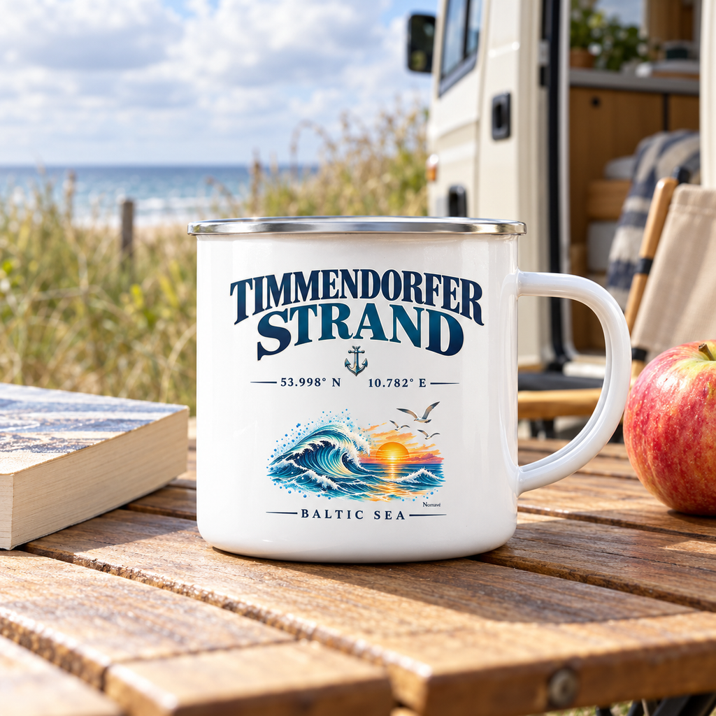 Emaille-Tasse 300 ml in Weiß mit Silberrand und Timmendorfer-Strand–Baltic-Sea-Motiv: Becher steht auf einem Campingtisch neben Buch und Apfel am Camper.