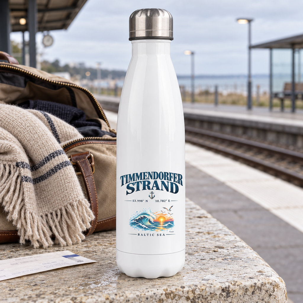 Thermoflasche 500 ml in Weiß mit Silberdeckel und Timmendorfer-Strand–Baltic-Sea-Motiv im unteren Flaschenbereich: Flasche steht neben einer Reisetasche am Bahnsteig.