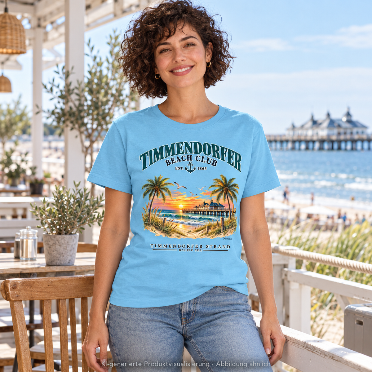 KI-generierte Produktvisualisierung: Frau auf einer Caféveranda am Meer im Timmendorfer Beach Club Damen Bio-T-Shirt in Aqua Blue mit maritimem Frontprint.