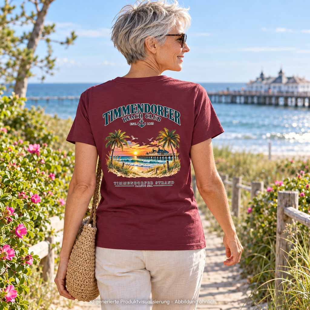 KI-generierte Produktvisualisierung: Frau im Damen Bio-T-Shirt Burgundy mit Timmendorfer-Beach-Club-Rückendruck auf einem Küstengartenweg.
