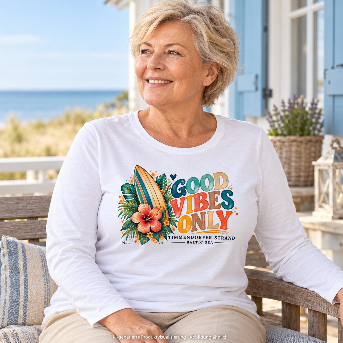 KI-generierte Produktvisualisierung: Frau im weißen Damen-Langarmshirt mit Surfboard-, Hibiskus- und Good-Vibes-Only-Frontprint auf einer Ferienhausterrasse am Meer.