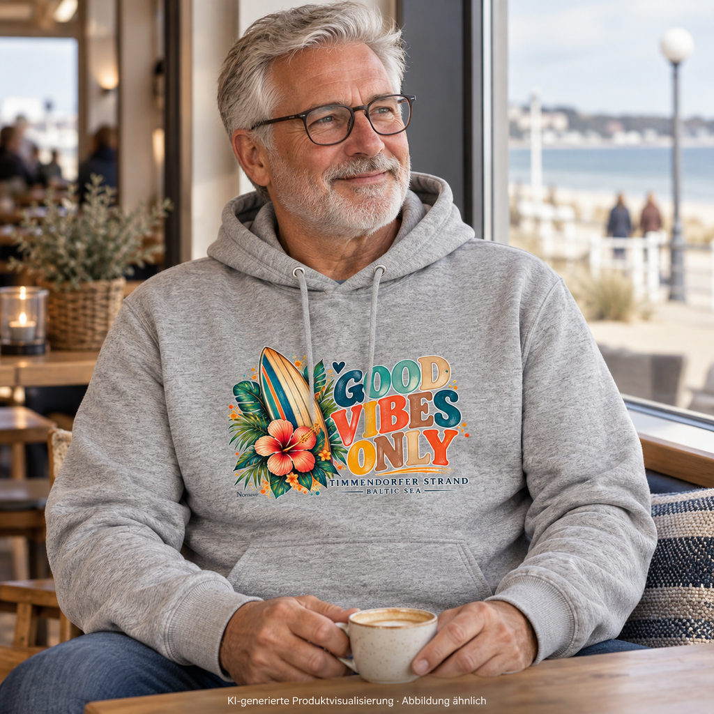 KI-generierte Produktvisualisierung: Mann im Bio-Kapuzenpullover in Heather Grey mit Surfboard-, Hibiskus- und Good-Vibes-Only-Frontprint am Fenster eines Küstencafés.
