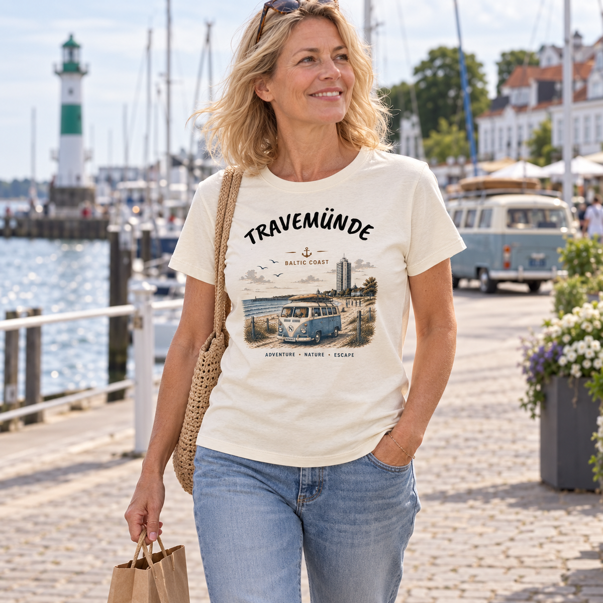 Frau im naturfarbenen Travemünde Bulli Bio T-Shirt beim Hafenbummel an der Ostsee