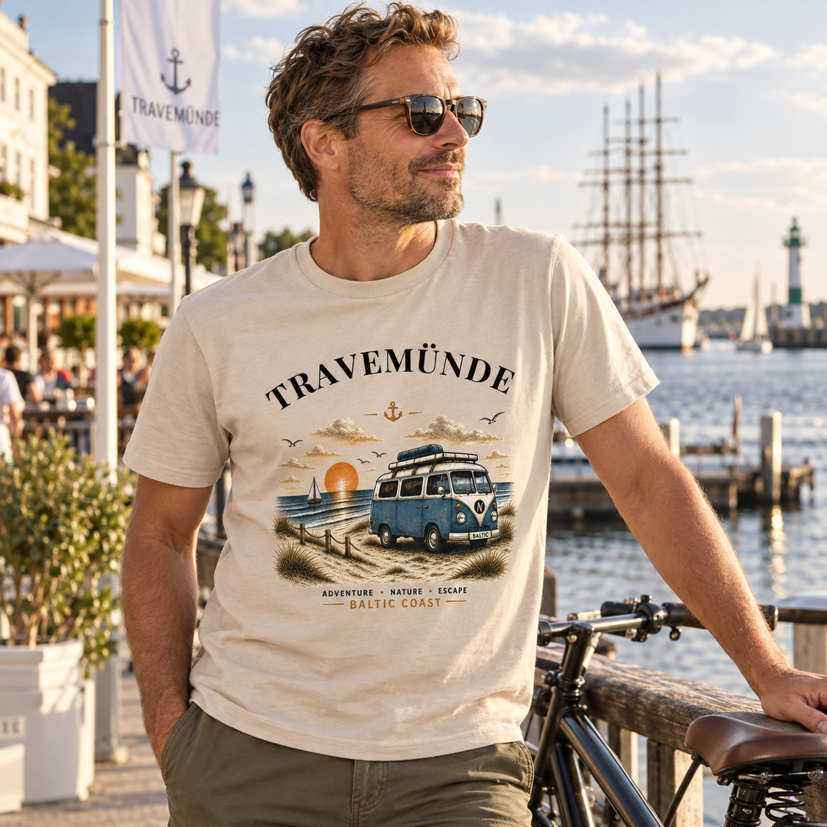 Mann im Travemünde Bulli Essential T-Shirt in Natural bei einer Fahrradpause am Hafen