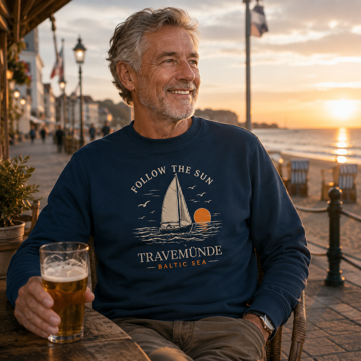 Mann trägt Travemünde Follow The Sun Dark Edition Sweatshirt an der Ostsee