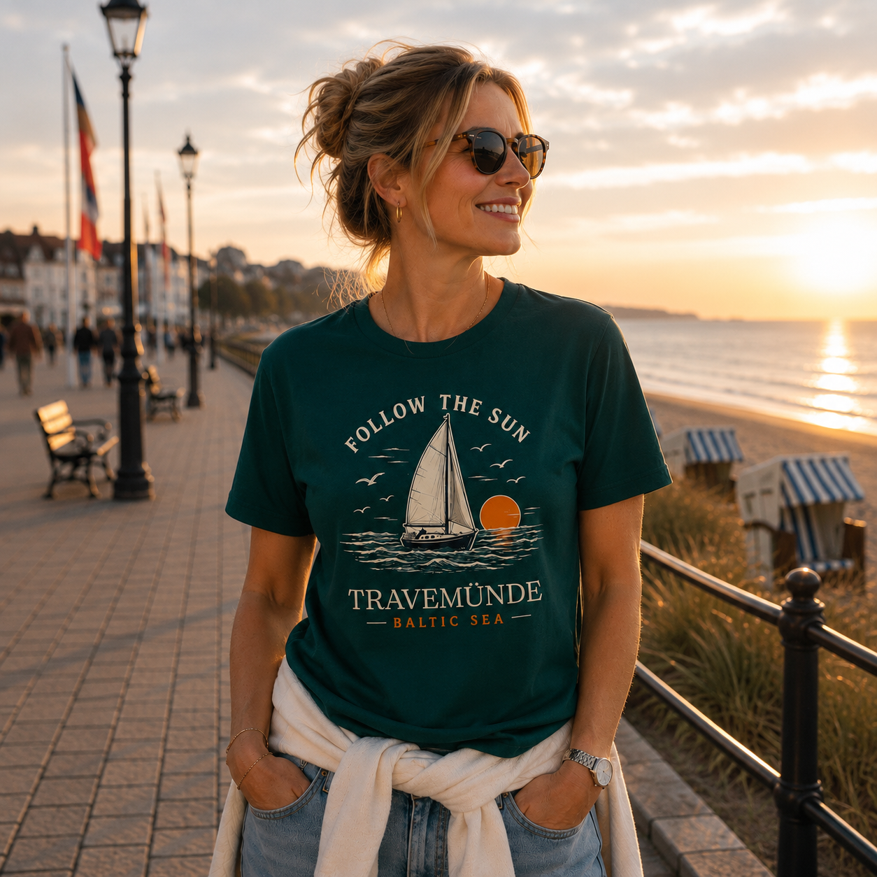 Frau trägt Travemünde Follow The Sun Dark Edition T-Shirt an der Ostsee