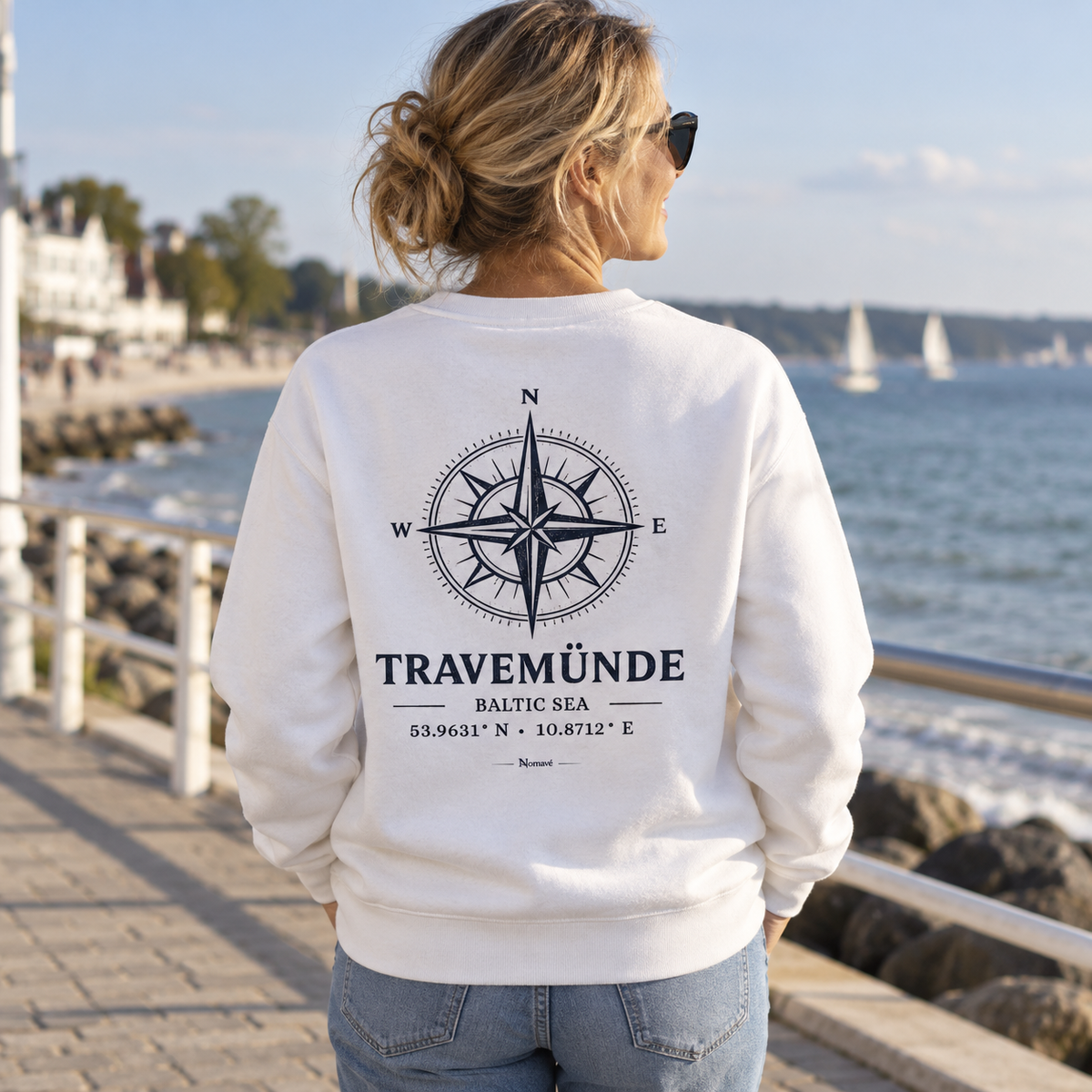 Frau im weißen Travemünde Windrose Bio-Sweatshirt an der Ostsee-Promenade