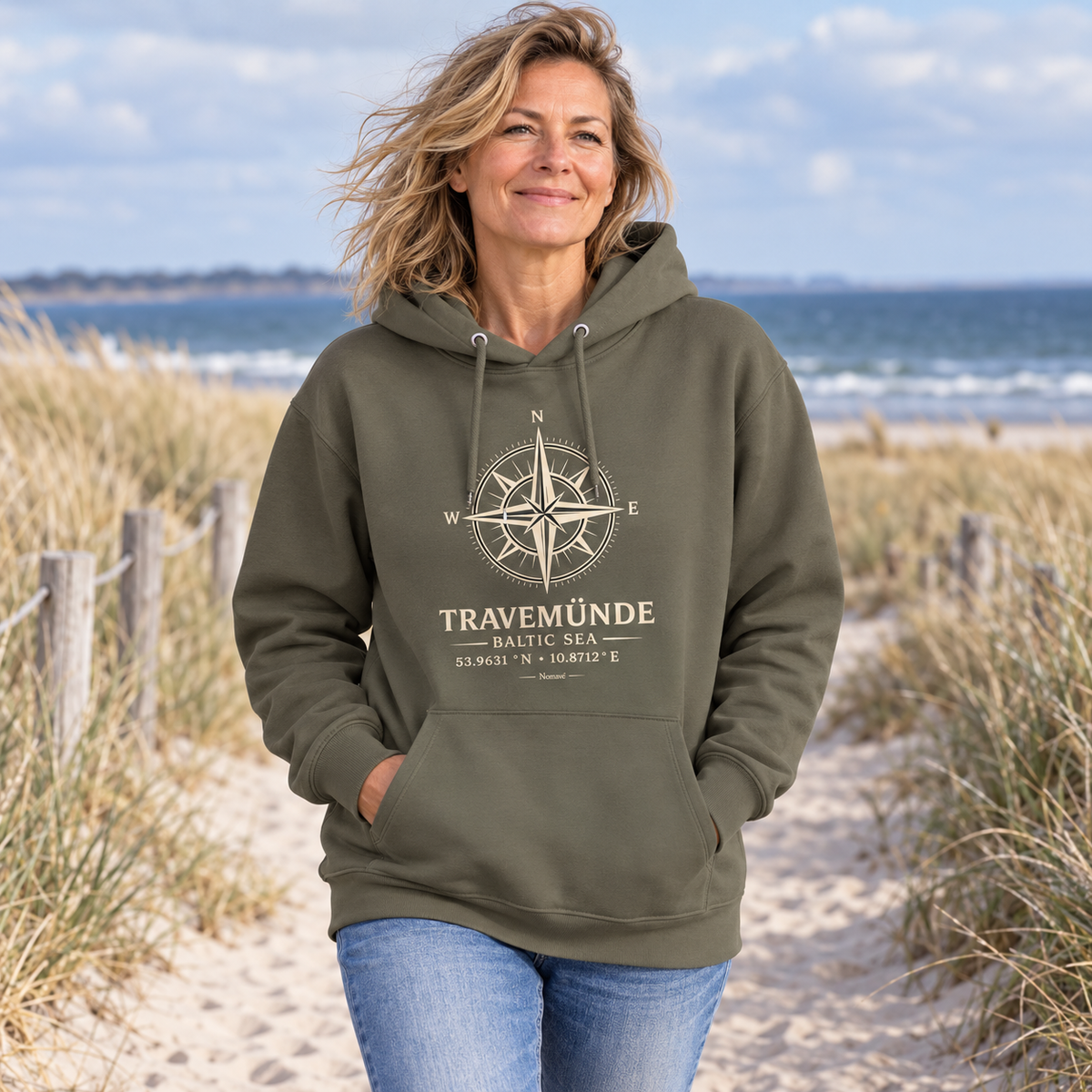 Frau im khakifarbenen Travemünde Windrose Bio-Hoodie am Ostsee-Dünenweg