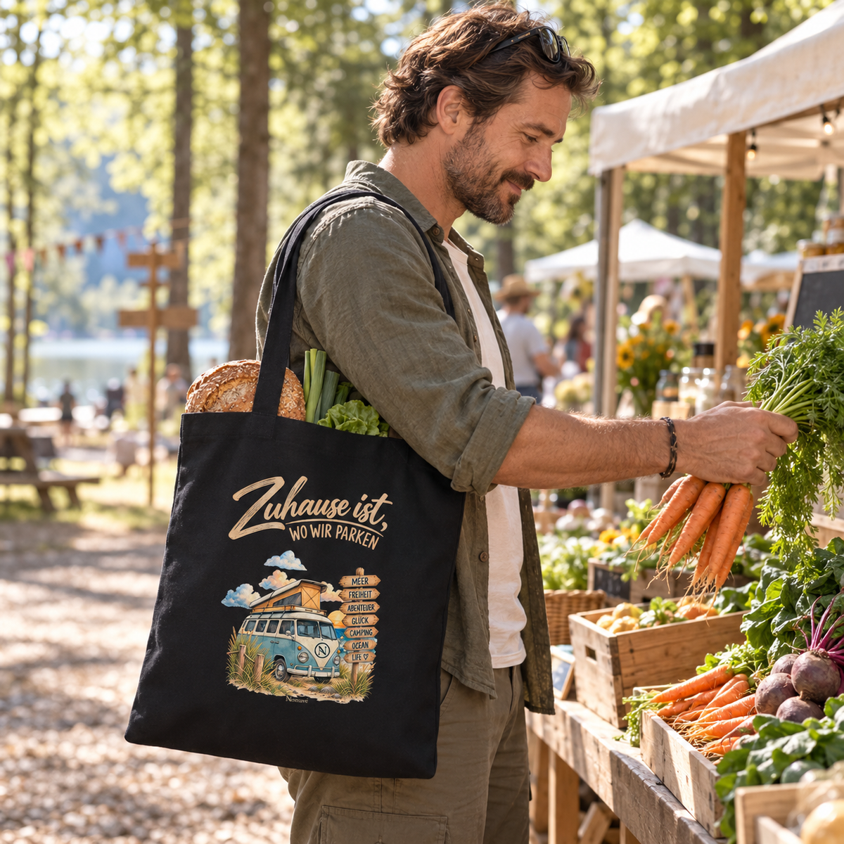 Schwarze Vanlife Bio-Einkaufstasche mit Campermotiv auf einem Markt am Campingplatz